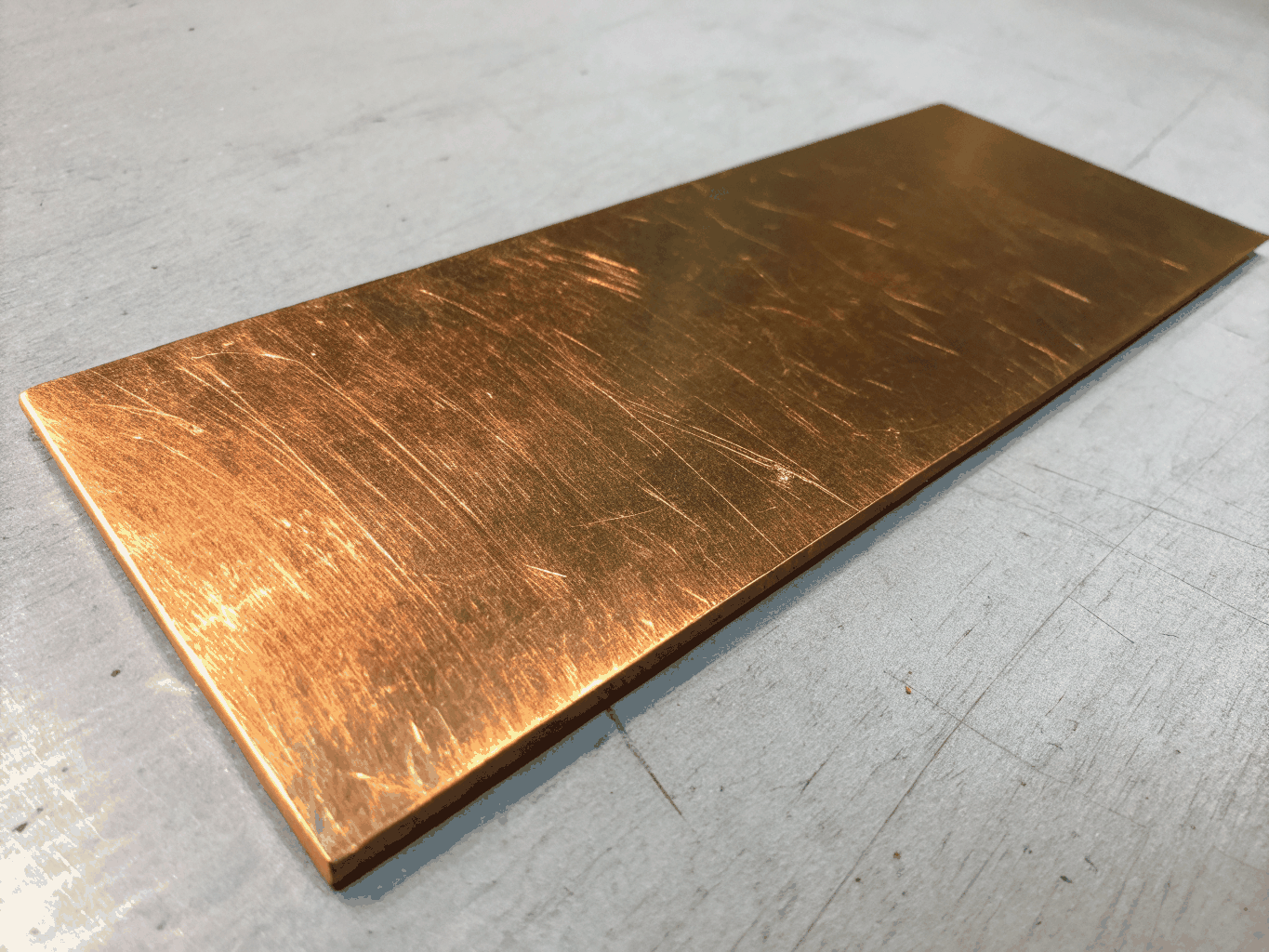 Laser engraving process on polished brass plate showing high contrast